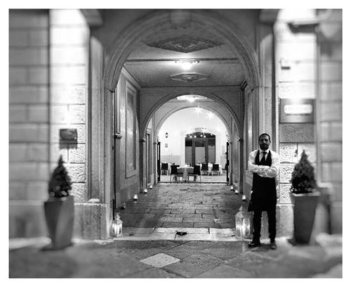 Un uomo in piedi in un corridoio in un edificio di VenuSuite VENOSA - Luxury House, Spa & Relax - a Venosa