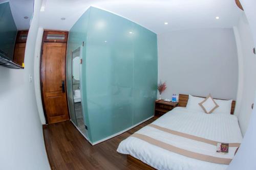 a small room with a bed and a glass wall at Bơ House hotel in Da Lat