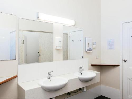 a bathroom with two sinks and a large mirror at Six Degrees Boutique Hotel in Albany