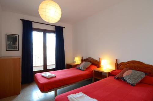 レスカラにあるApartamentos Els Pescadorsのベッドルーム1室(ベッド2台、窓付)