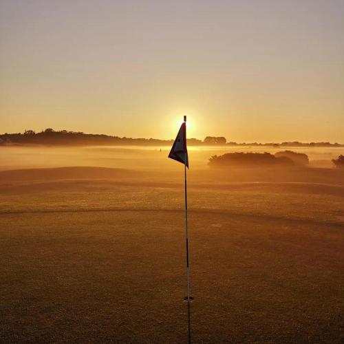 a flag on a golf course at sunset at Hotell Stavstensgården in Trelleborg