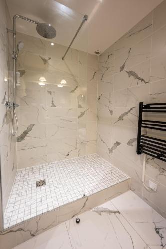a bathroom with a shower with a tiled wall at Best Western Adagio Saumur in Saumur