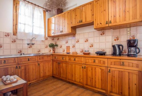 a kitchen with wooden cabinets and a sink at Villa Diamanti in Monemvasia
