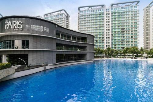 une grande piscine bleue en face d'un bâtiment dans l'établissement Azure 2BR Resort Living in the City with Wifi, à Manille