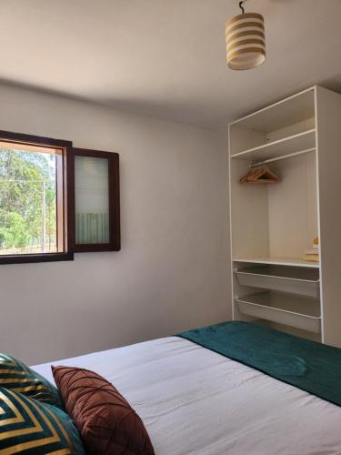 Schlafzimmer mit einem Bett, einem Spiegel und einem Fenster in der Unterkunft Quinta das Camarinhas in Cantanhede