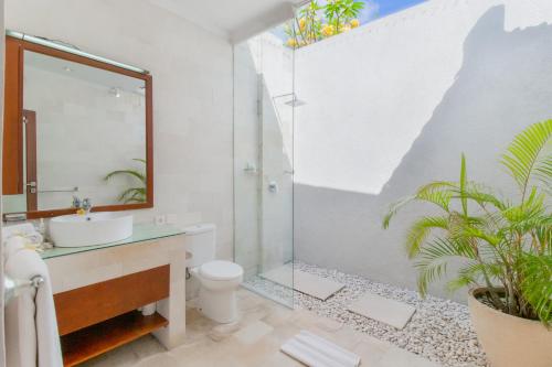 a bathroom with a sink and a toilet and a mirror at Villa Istana 1 in Seminyak