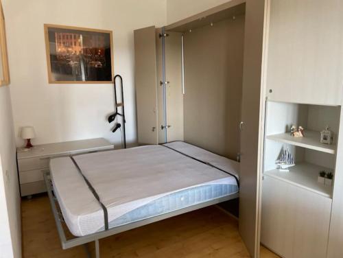 a small bedroom with a bed with a sliding door at Monolocale fronte mare in Livorno