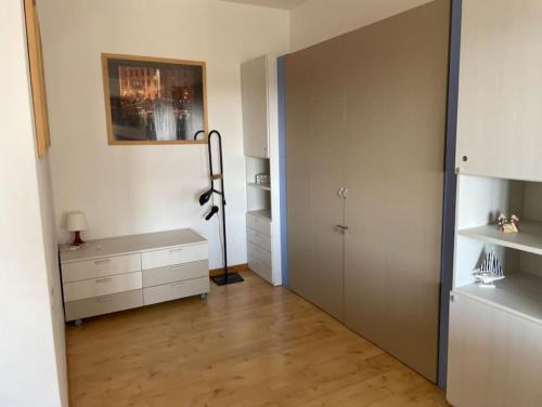 Habitación con armario, escritorio y puerta. en Monolocale fronte mare, en Livorno