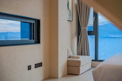 a bedroom with a bed and a window with a chair at Dali Oriental Seaview Hotel -Dali Erhai in Dali