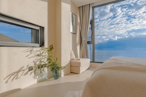 a bedroom with a large window overlooking the water at Dali Oriental Seaview Hotel -Dali Erhai in Dali