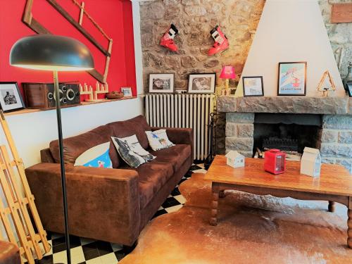 a living room with a couch and a fireplace at Hôtel Les Mouflons in Le Mont-Dore