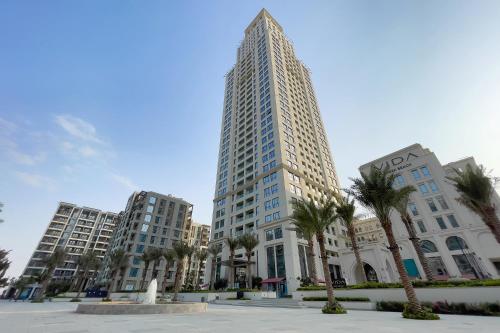 a tall building with palm trees in front of it at Luxury apartments at Vida Residences in Dubai