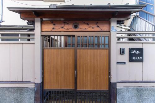 an entrance to a building with a wooden door at 和氣会々新大久保 Wakiaiai Shinokubo in Tokyo