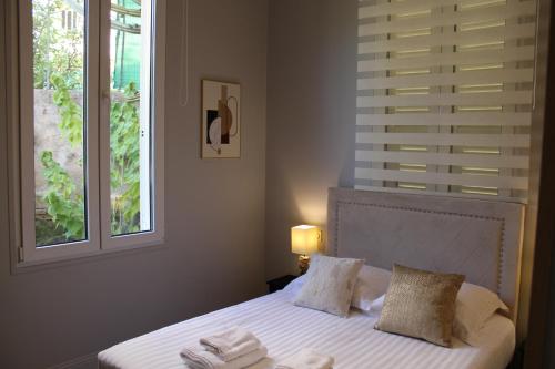 une chambre avec un lit avec des draps blancs et une fenêtre dans l'établissement MAISON AVEC SPLENDIDE VUE MER et MONACO 5 minutes des PLAGES, à Roquebrune-Cap-Martin