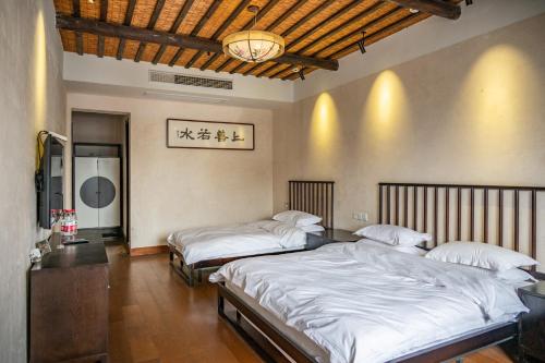 Tingjian Musu Private Soup Design Homestay - South Gate of Wuzhen Xizha Scenic Areaにあるベッド