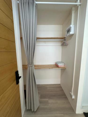 a closet with a curtain in a room at Letter Better Home in Bangkok