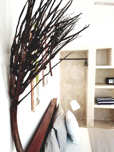 Michamvi Spirit Lodge في ميتشامفي: غرفة نوم مع سرير مع شجرة على الحائط