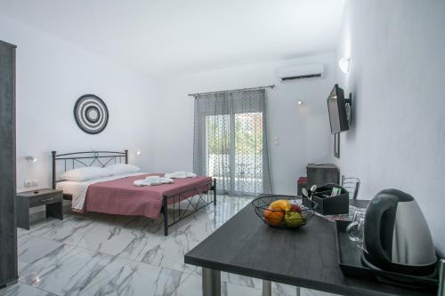 a bedroom with a bed and a table with a bowl of fruit at Dorian's Domain Faliraki in Faliraki