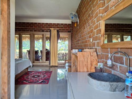 uma casa de banho com um lavatório e uma parede de tijolos em Bunga Maliq Bungalow Lombok em Tetebatu