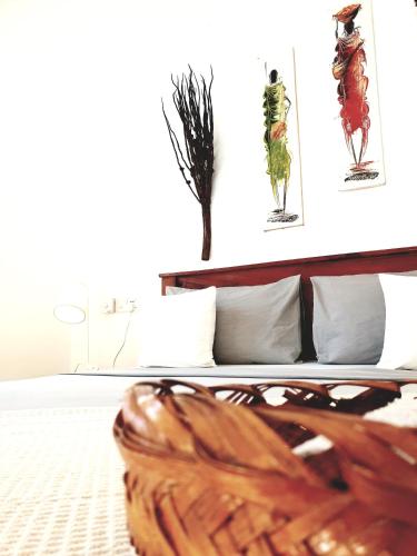 a bedroom with a bed with paintings on the wall at Michamvi Spirit Lodge in Michamvi