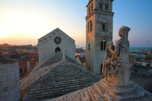 a building with a clock tower and a statue at LITHOS guest room in Barletta