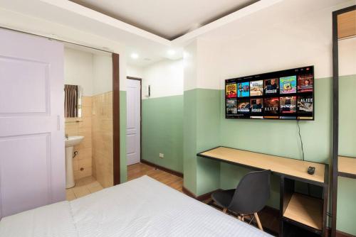 マニラにあるSt. Marvin Studio Makati M203のベッドルーム1室(ベッド1台、デスク、壁掛けテレビ付)