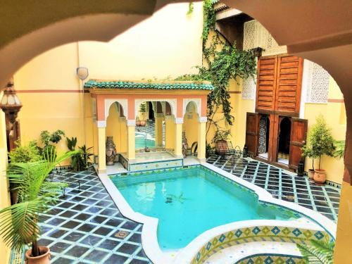 an indoor swimming pool in a house with a courtyard at Riad Zitouna in Fez