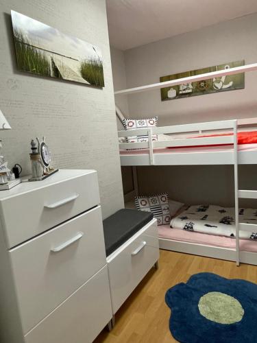 - une chambre pour enfants avec des lits superposés et un tapis dans l'établissement Bungalow am Schwielochsee 2.0, à Schwielochsee