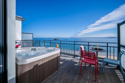 a hot tub on a balcony with a view of the ocean at Hôtel la Baie Valdys Resort & SPA in Douarnenez