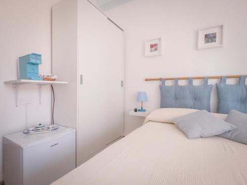 a white bedroom with a bed and a mirror at A 50 scalini dal mare - Camera Doppia Privata in Maratea