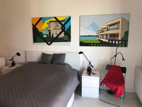 a bedroom with a bed and two paintings on the wall at Art House - Révfülöp in Révfülöp