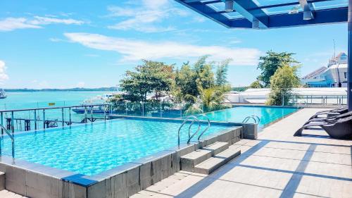 a large swimming pool next to a body of water at Palam Mansion at Apartment One Residence in Batam Center