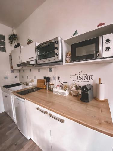uma cozinha com um balcão de madeira e um micro-ondas em Gîte La Truyère em Entraygues-sur-Truyère