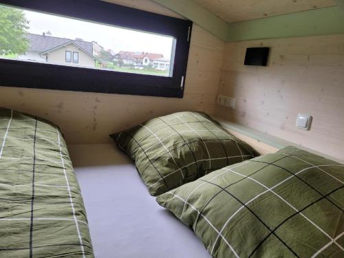 2 Betten in einem kleinen Zimmer mit Fenster in der Unterkunft Woidwogn in Mauth