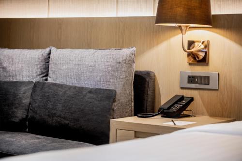 a room with a couch and a table with a telephone at Hotel Valletta in Jiaoxi