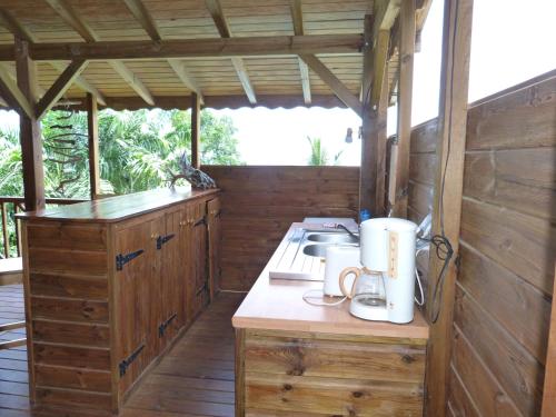 a kitchen in a wooden cabin with a counter at les hauts de deshaies in Deshaies