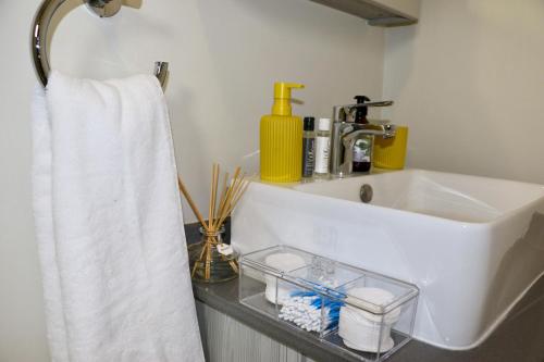 een badkamer met een wastafel en een handdoek bij The Red Portrait at Carlswald in Midrand