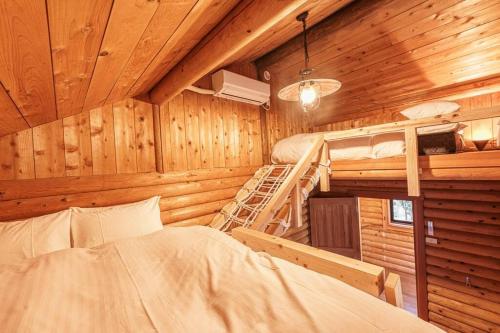 Un dormitorio con una cama y una escalera en una cabaña en VILLA ATAMI -Maruta- en Atami