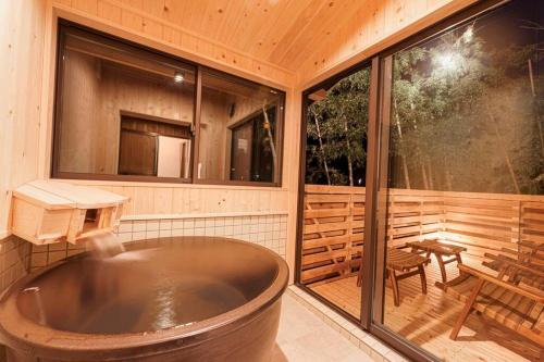 eine große Badewanne auf einer abgeschirmten Veranda in der Unterkunft VILLA ATAMI -Maruta- in Atami