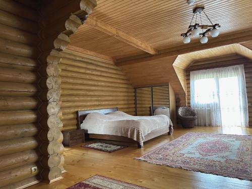 1 dormitorio con 1 cama en una habitación con paredes de madera en Сонячний Лаз, en Polyana