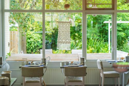 a dining room with a table and chairs and a window at Hotel Kijkduin in Domburg