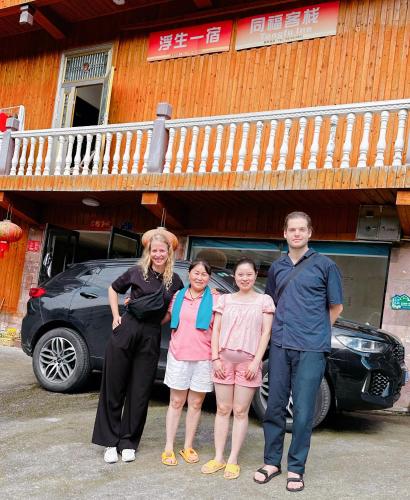 a group of people standing in front of a car at Tongfu Inn(In the National Park) in Zhangjiajie