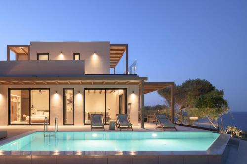 une villa avec une piscine en face d'une maison dans l'établissement Irida Hotel Agia Pelagia, à Agia Pelagia
