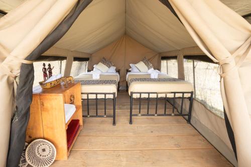 a room with four beds in a tent at Africa Safari Serengeti Ikoma Camping in Serengeti