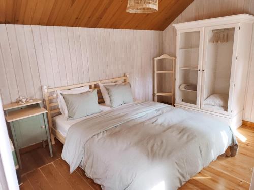 1 dormitorio con 1 cama blanca grande y armario en Casinha do pinhal, en Colares