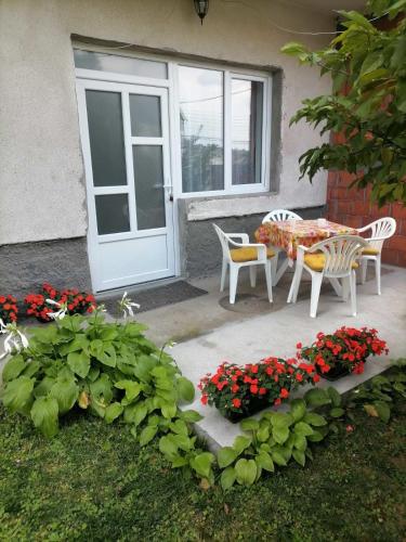 eine Terrasse mit Tisch und Stühlen und einer Tür in der Unterkunft Pavicevic in Sokobanja