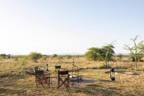 a group of chairs and tables in a field at Africa Safari Serengeti Ikoma Camping in Serengeti