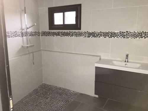La salle de bains blanche est pourvue d'un lavabo et d'une douche. dans l'établissement Villa Paradise, à Gémenos
