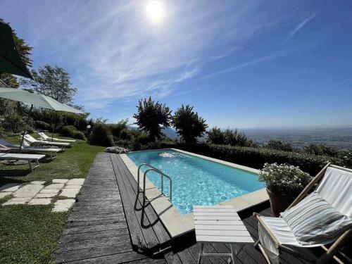 a swimming pool with chairs and a view of the ocean at Il nido della Moresca in Montecatini Terme