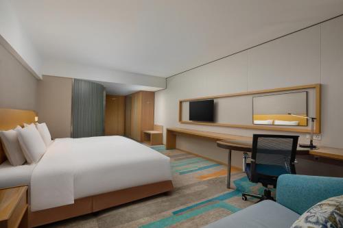 a hotel room with a bed and a desk and a tv at Holiday Inn Express Xi'an Qujiang South by IHG in Xi'an